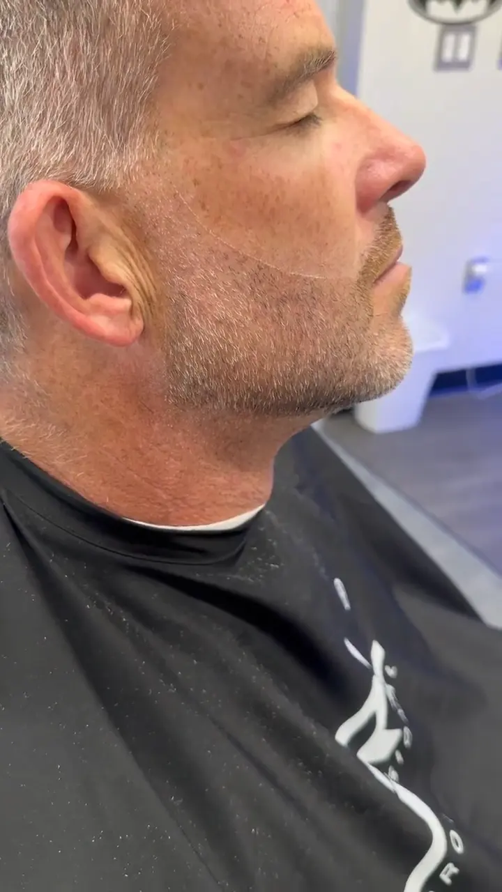 Anthony Hicks edging a crisp beard line with a straight razor at his Palm Beach Gardens barbershop