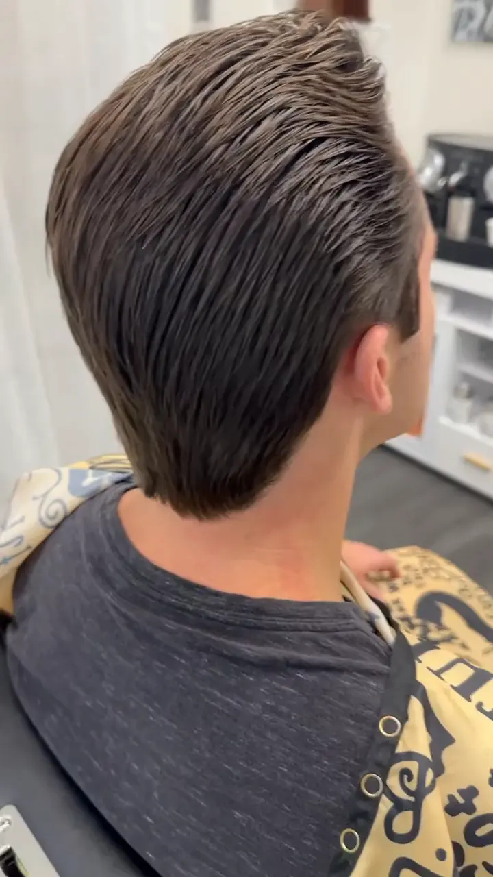 Slick back taper with a sharp side part and clean tapered sides